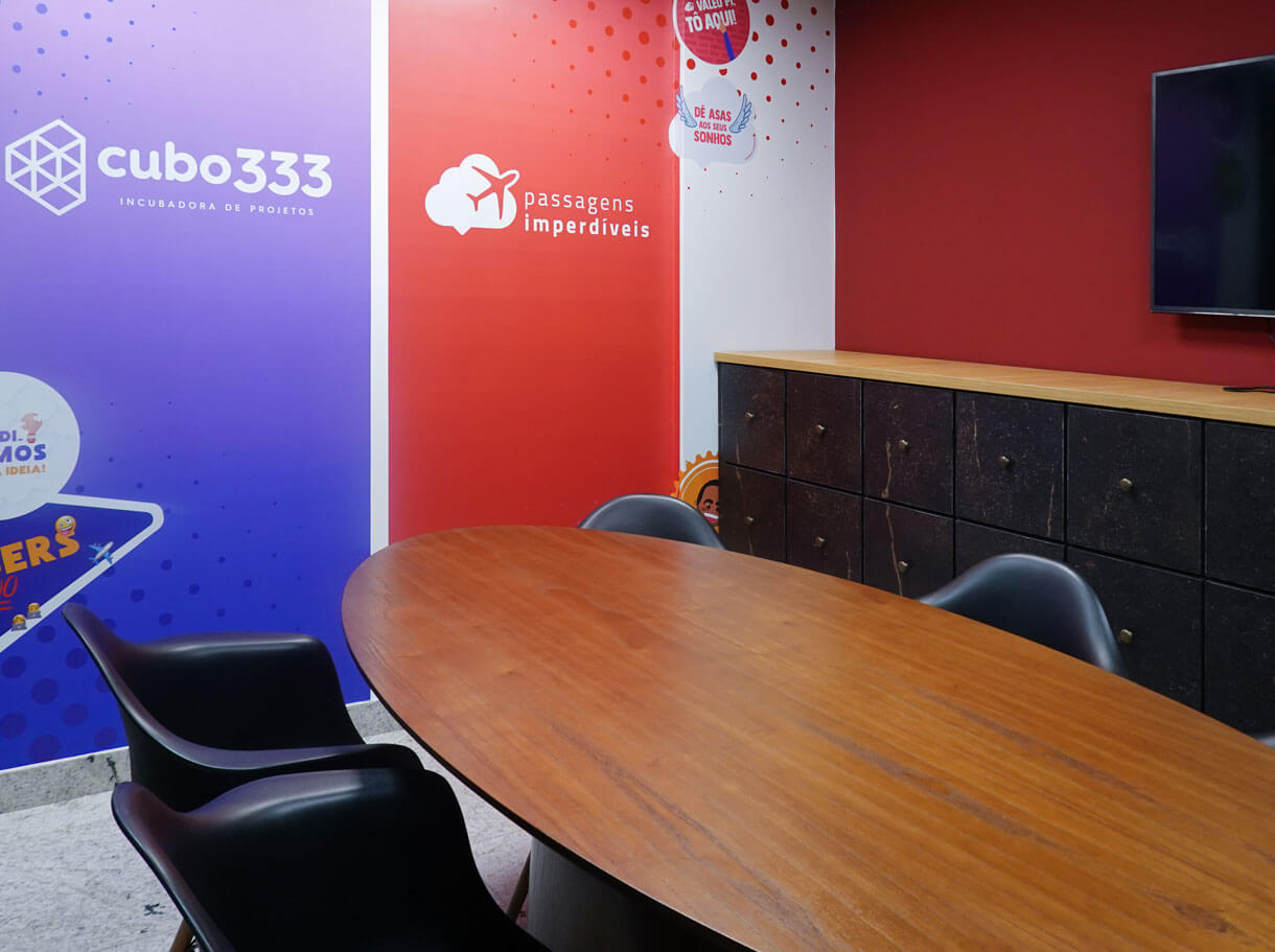 Sala de reunião da Cubo333 com os banners da marca e do Passagens Imperdíveis